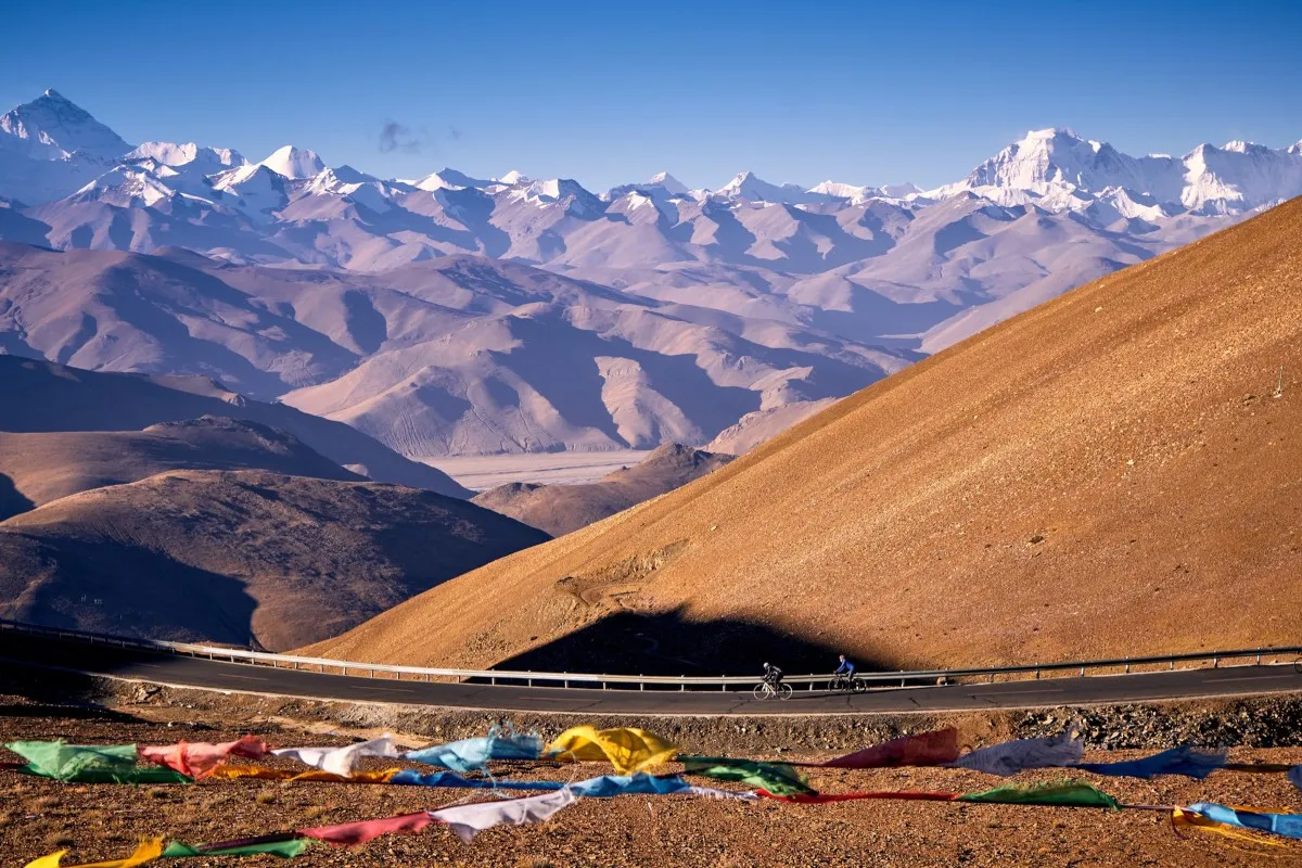 Panorama of the Himalayas with cyclists on the road
